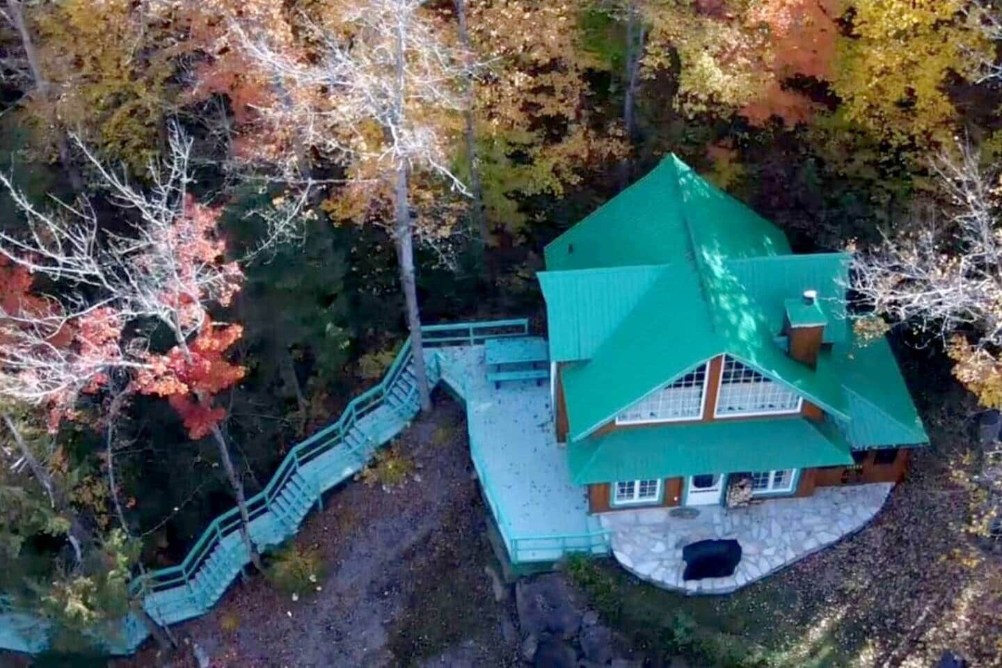 Une maison dotée d’un toit végétalisé, d’une terrasse en pierre et d’un escalier menant à l’entrée.