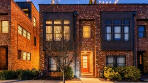 A modern multi-story residential building with brick facades and large windows.