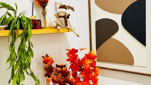 Une étagère avec une plante, un objet décoratif et une œuvre d’art encadrée.
