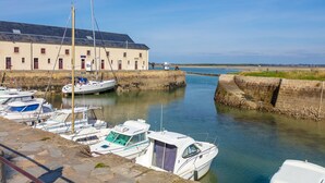 Un puerto deportivo con barcos amarrados, un edificio con varias ventanas y un cielo despejado.