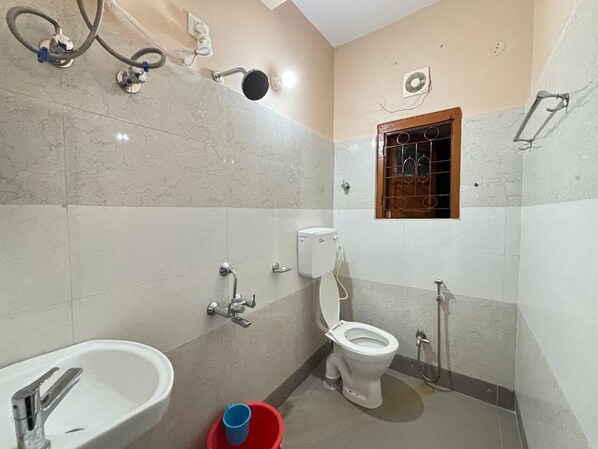 A compact bathroom with a toilet, sink, and shower. - Sri Mayapur Chandrodaya Guest House (Krishnanagar)