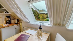A kitchen with a window, a kettle, a coffee maker, and a bottle of wine. - Apartment 'Karroo' with Shared Garden and Wi-Fi (Wittdün)