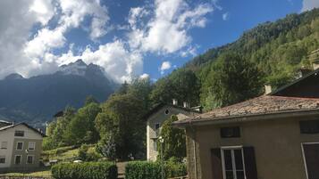 A mountain village with traditional buildings, a clear sky, and a mountain backdrop.