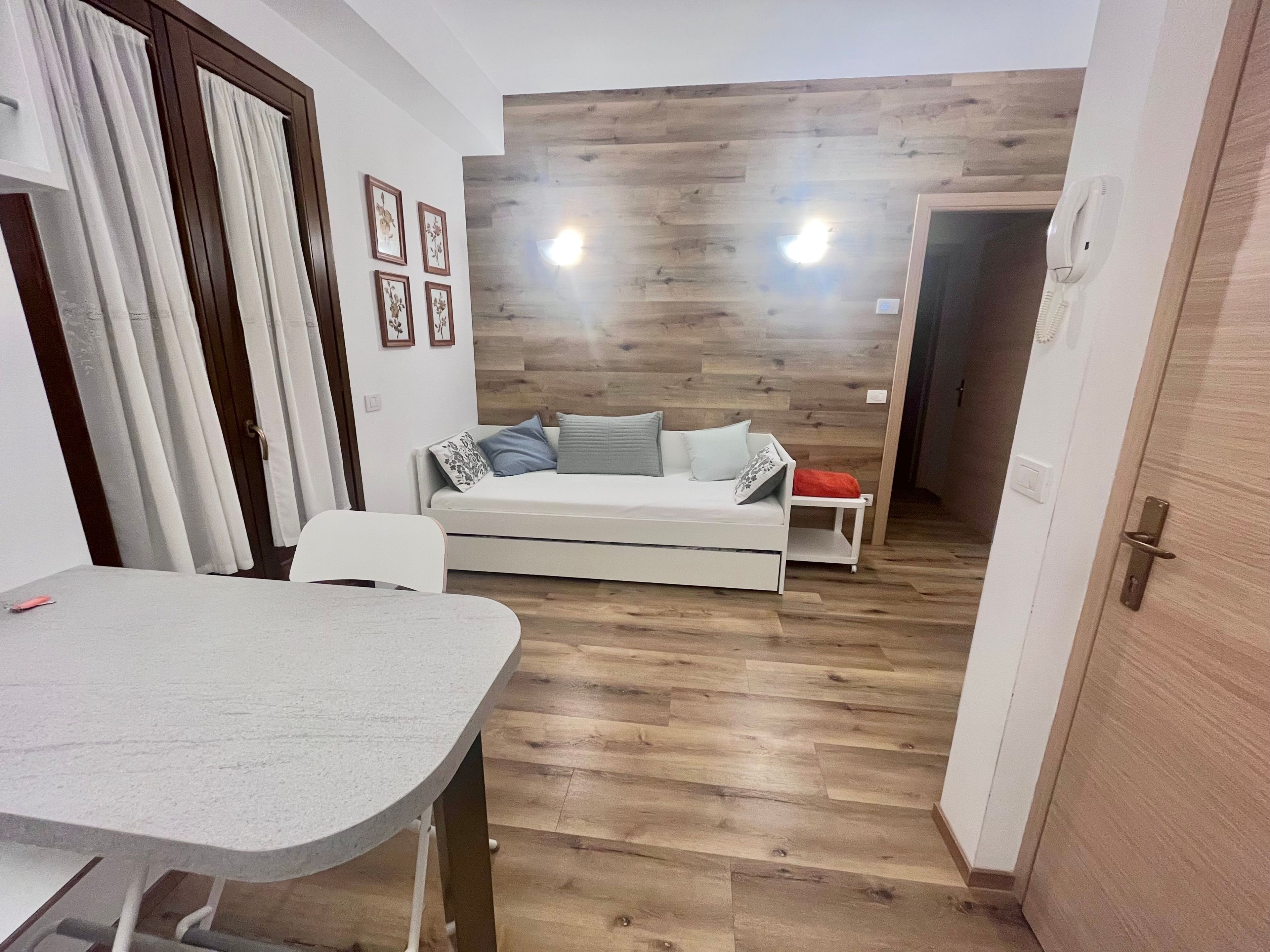 Ein kompakter Wohnbereich mit einer Couch, einem kleinen Tisch und einer Wand als Holzdekor.