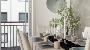 Una mesa puesta con platos, vasos y un florero con flores.