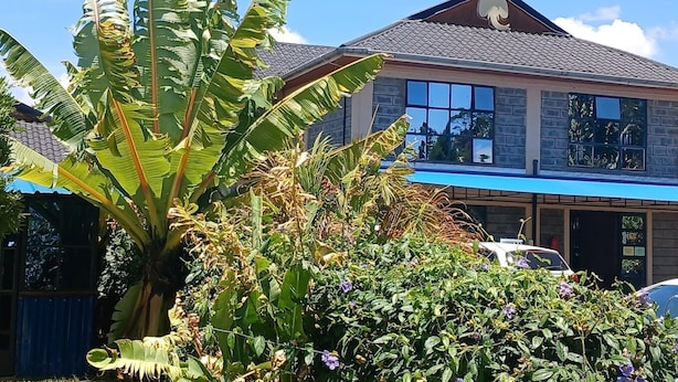 A two-story house with a tiled roof, large windows, and a garage. - Jafra Elephant Inn (Eldoret)