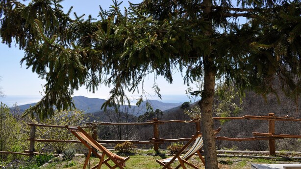 A wooden deck with two folding chairs, a wooden fence, and a view of mountains. - Room 'Stanza 1' with Sea View, Shared Terrace and Wi-Fi (Castiglione Chiavarese)