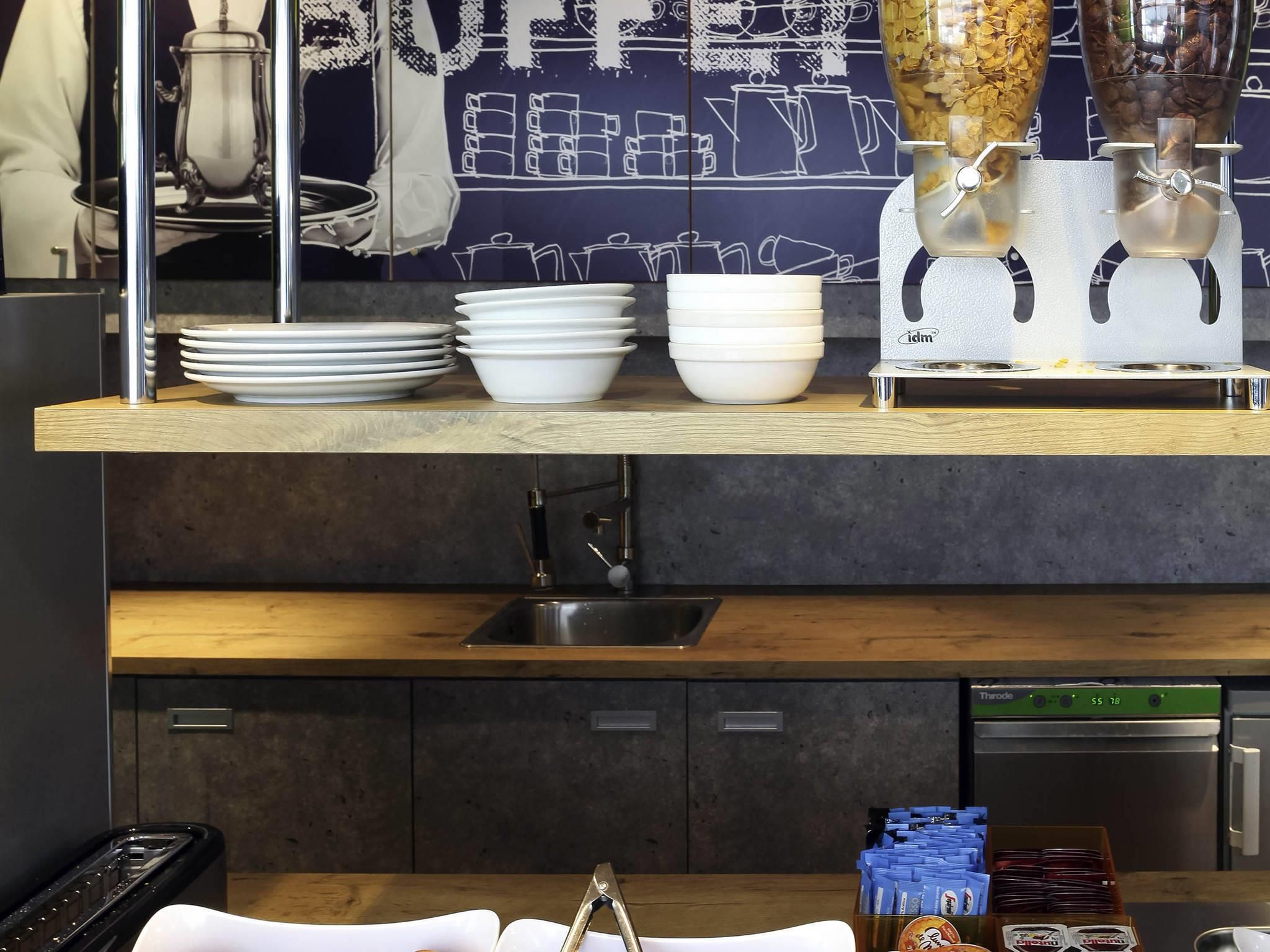 A kitchen with a wooden countertop, a sink, and a coffee machine.