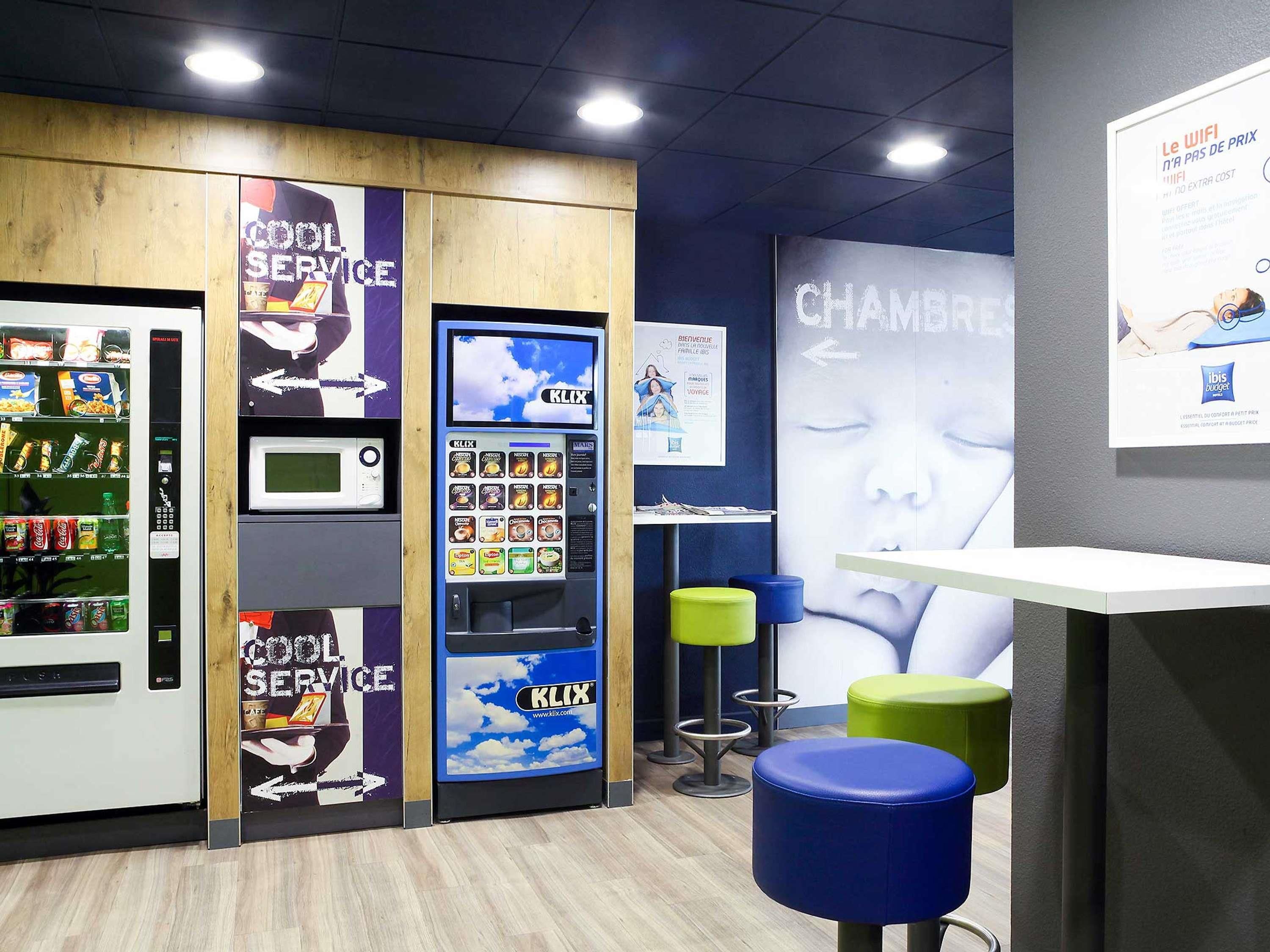 A modern kiosk with a microwave, vending machines, and a digital screen advertising 'CLIX'.