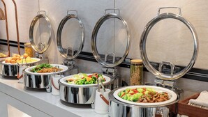 A buffet line with various dishes, including pasta, salads, and stir-fries, arranged on a counter with stainless steel serving ware. - Mercure Beijing The Grand Canal Cbd (Tongzhou)