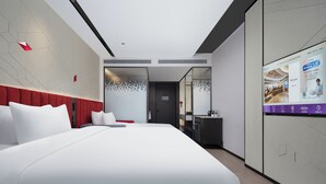 A modern hotel room with a large bed, a red accent wall, a bathroom with a mirror, and a digital screen displaying information. - Mercure Beijing The Grand Canal Cbd (Tongzhou)