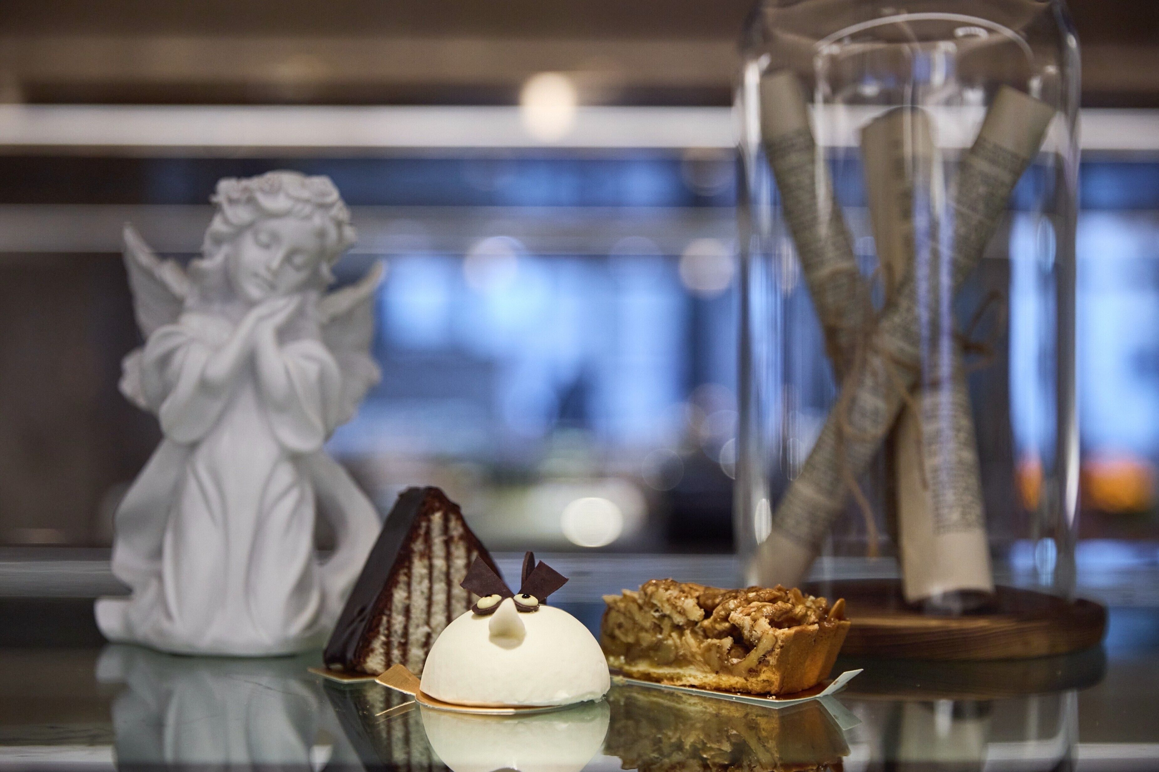 A dessert display with a cake, a pastry, and a glass jar with a decorative item.