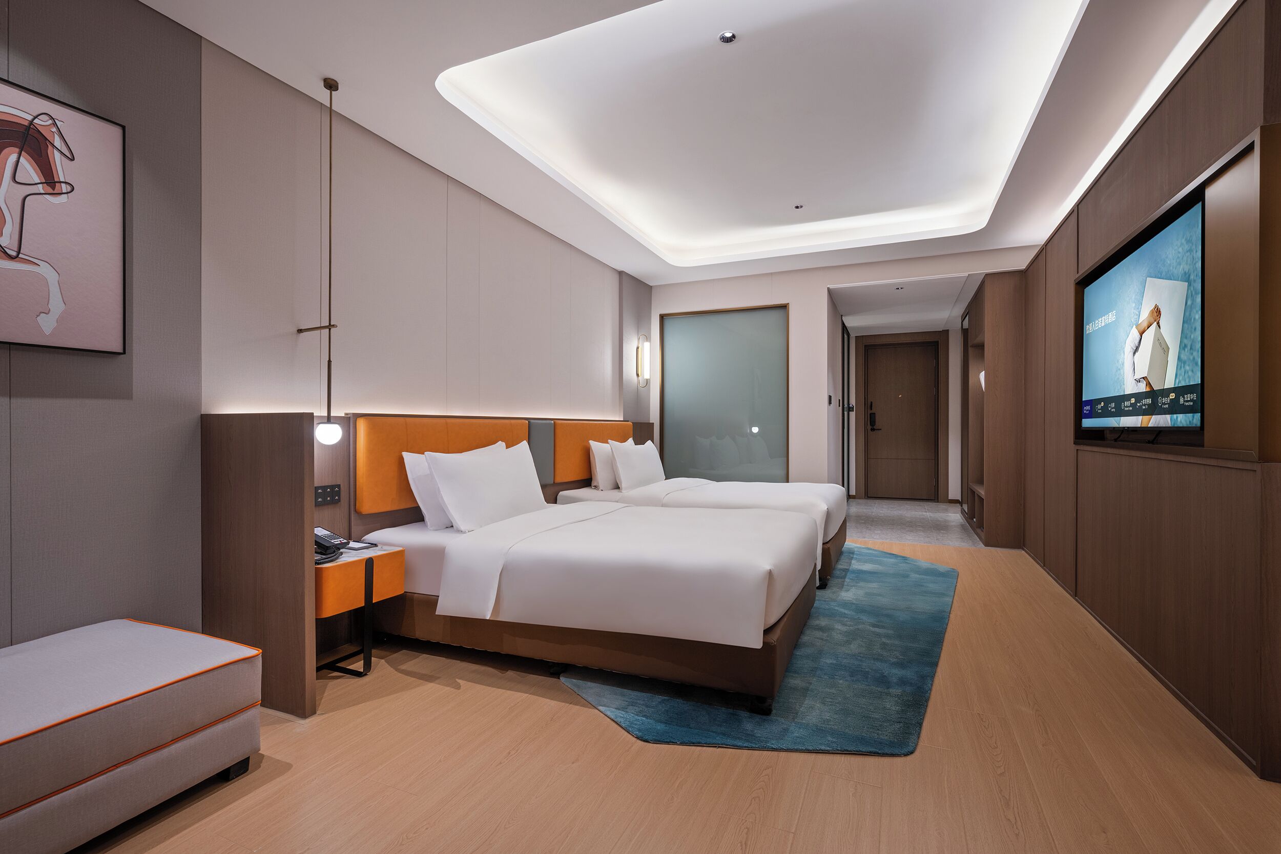 Ein modernes Hotelzimmer mit einem großen Bett, Nachttischen, einem Flachbildfernseher und einem blauen Teppich.