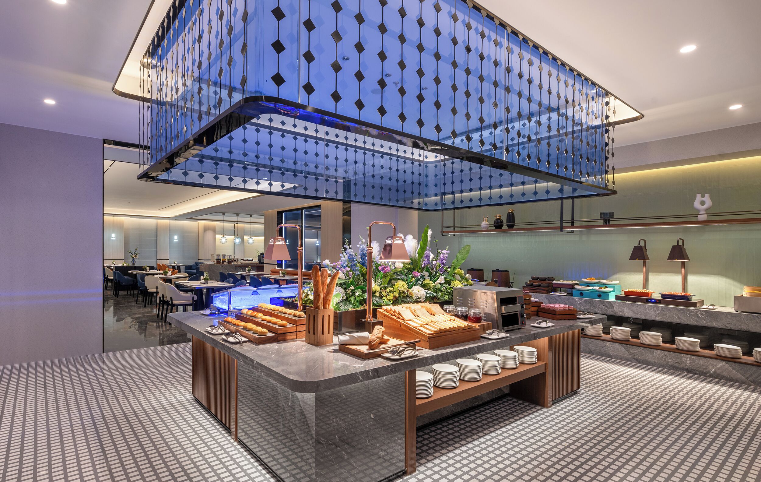Eine moderne Hotelhalle mit einer zentralen Rezeption, einer Lounge und einem dekorativen Glastrennwand.