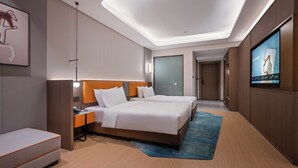 A modern hotel room with a large bed, a desk, a TV, and a blue rug. - Novotel Hangzhou Xintiandi (Hangzhou)