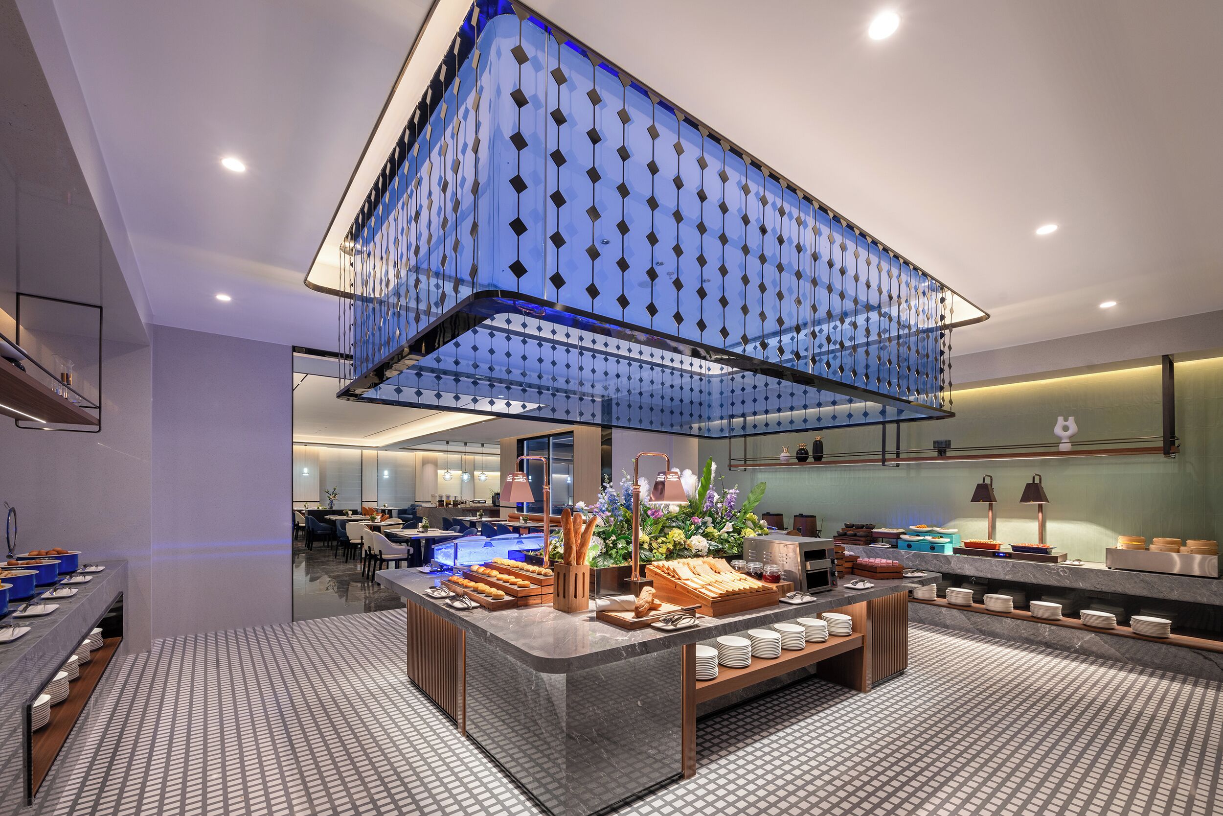 Eine moderne Hotellobby mit einer großen Glaswand, einem Empfangsbereich und einem Buffet.