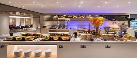 En buffet med forskellige retter og en dekorativ Eiffeltårn-midterstykke.