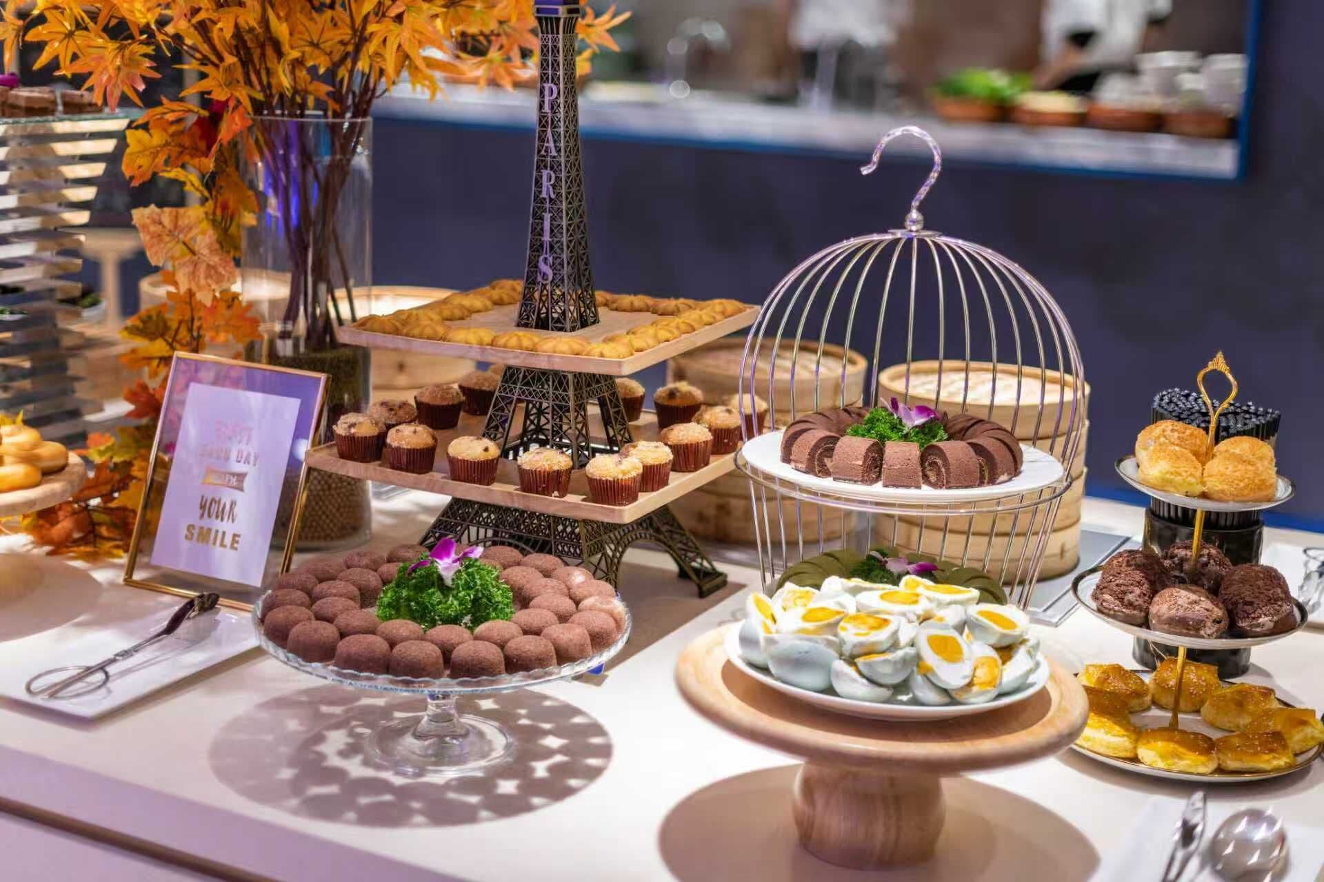A dessert display with various pastries and a sign that reads 'Happy Birthday Your Smile'.