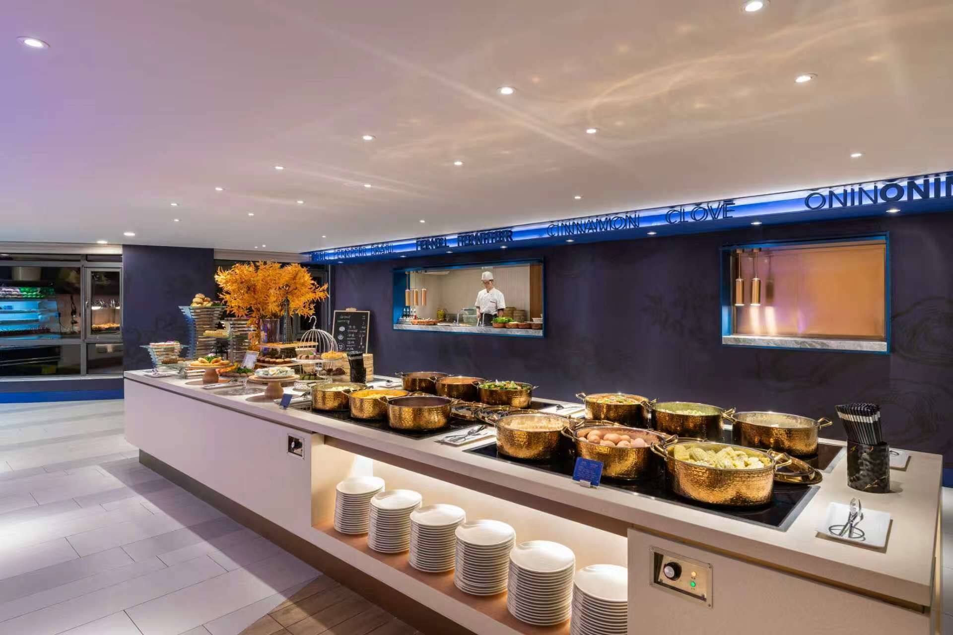 A buffet area with various food dishes, a chef preparing food, and a sign indicating 'ONION LOVE.'