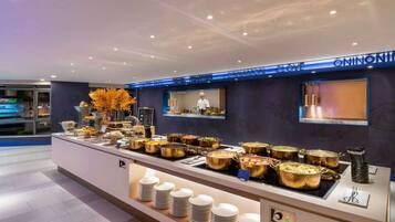 A buffet area with various food dishes, a chef preparing food, and a sign indicating 'ONION LOVE.'