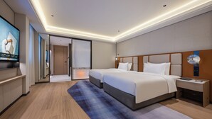 A modern hotel room with a large bed, a TV, and a desk with a lamp. - Novotel Shanghai Hongqiao International Airport (Shanghai)