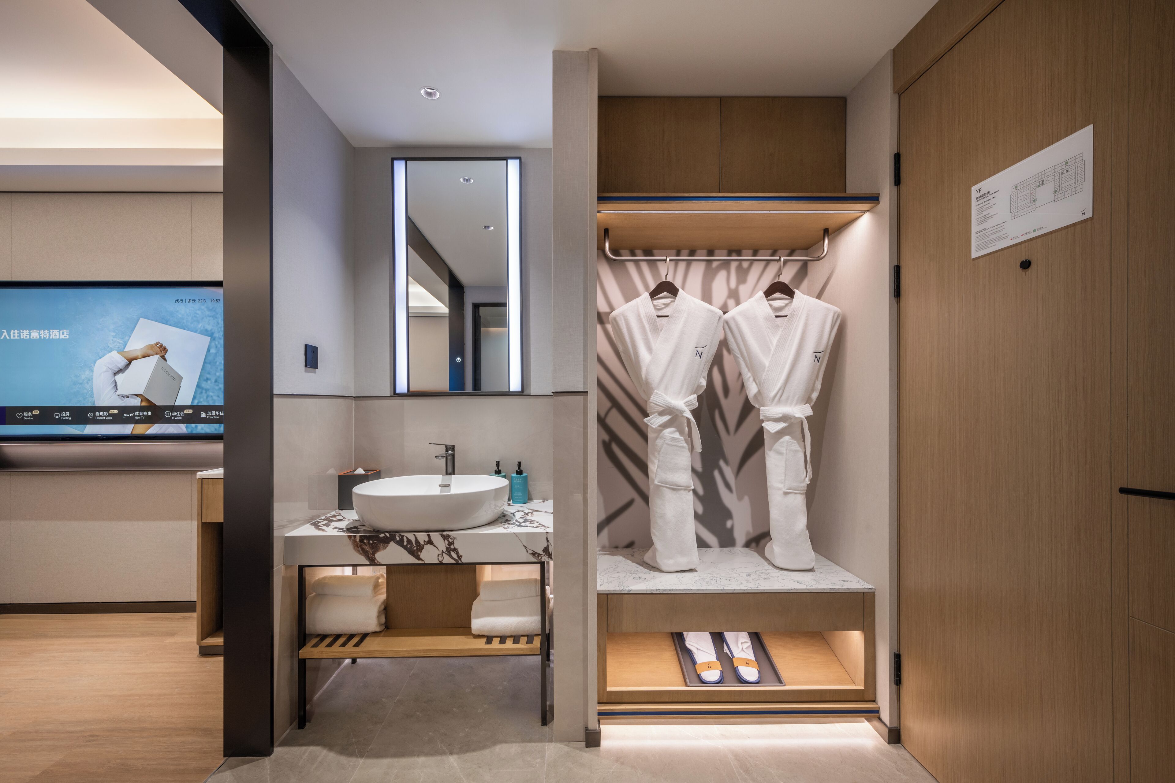 A modern bathroom with a sink, mirror, and towel rack.