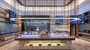 A buffet area with various food stations and a large digital screen displaying content. - Novotel Shanghai Hongqiao International Airport (Shanghai)