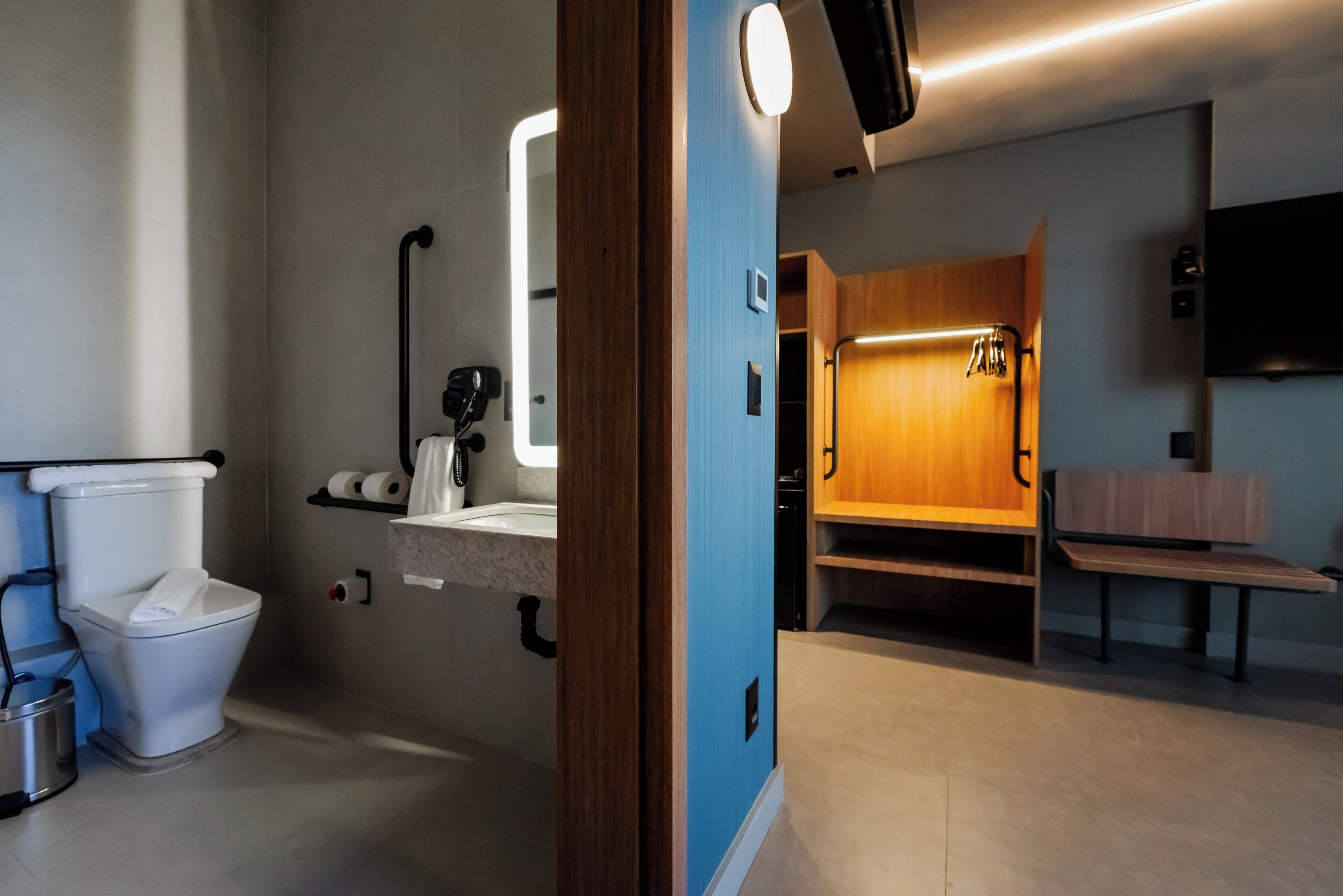 A modern bathroom with a toilet, sink, and mirror.