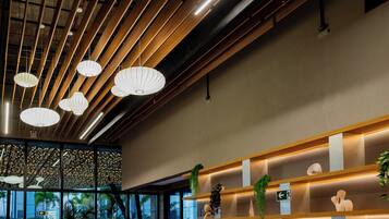 Un interior moderno con listones de madera en el techo y luces colgantes.