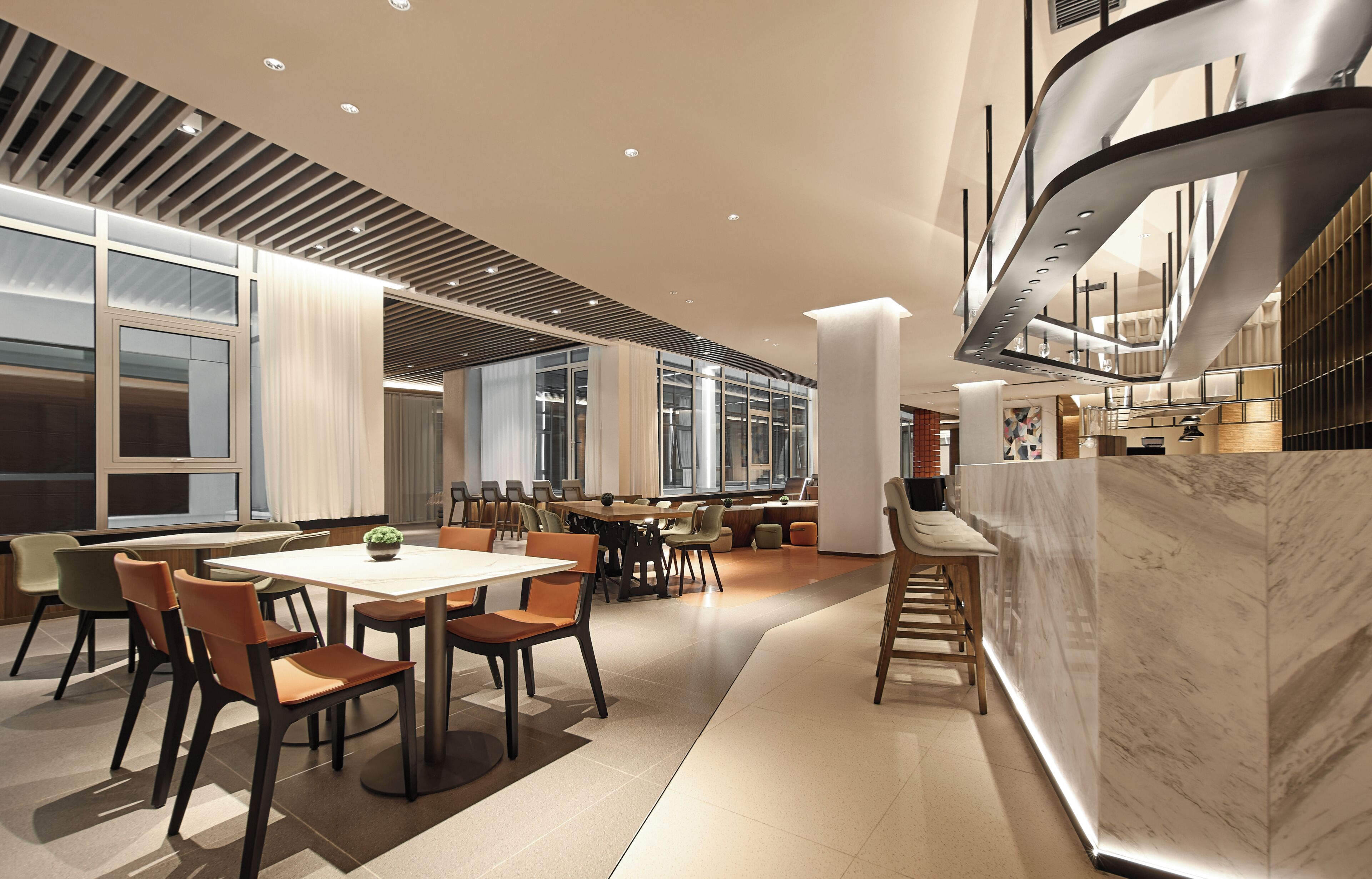 A modern interior with a dining area, kitchen, and bar/lounge area.