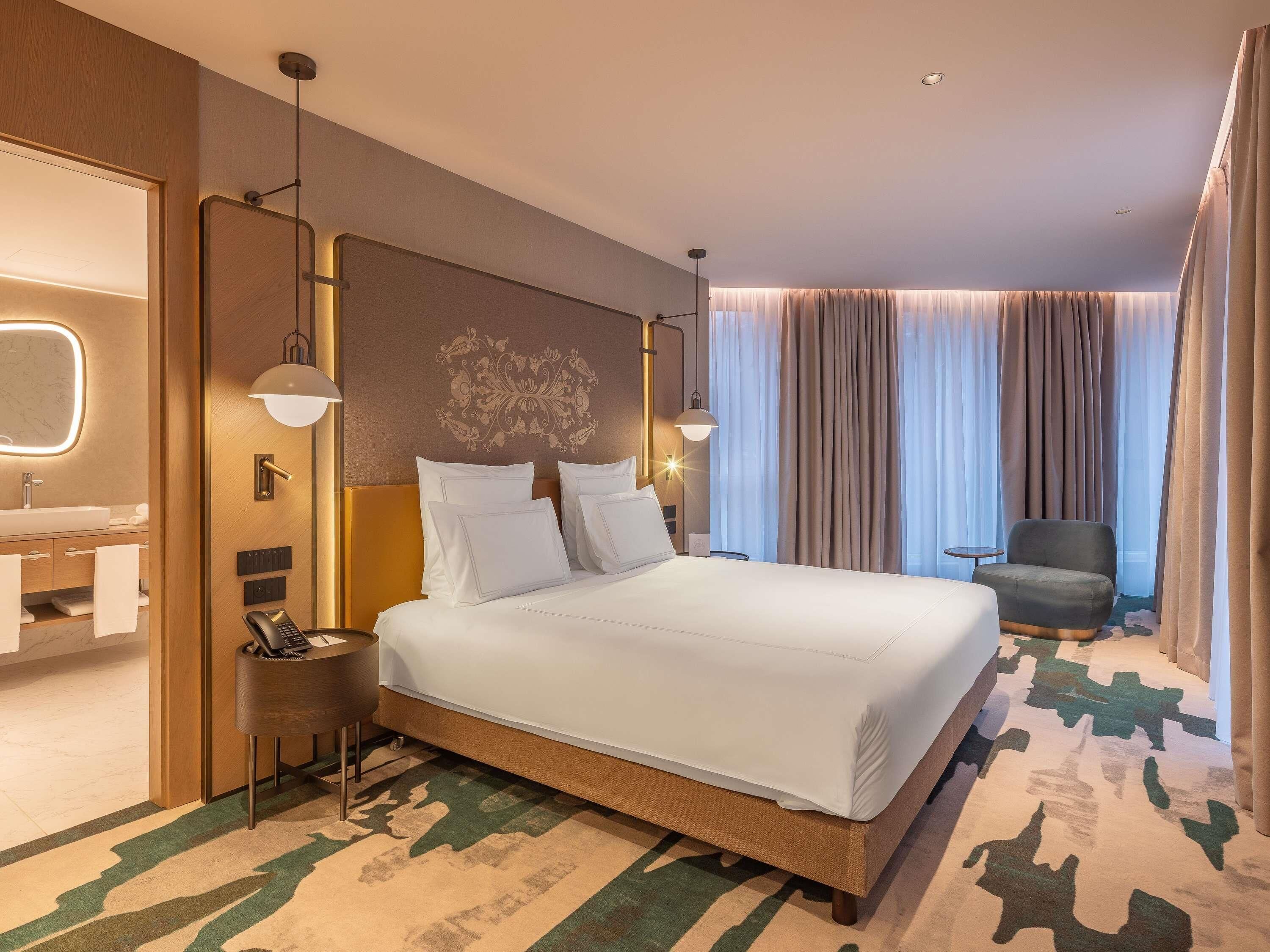 Deluxe Suite, 1 King Bed (Atrium View) | Ylelliset vuodevaatteet, minibaari, tallelokero huoneessa, työpöytä