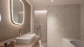 A modern bathroom with a large mirror, a sink, a shower, and a bathtub.