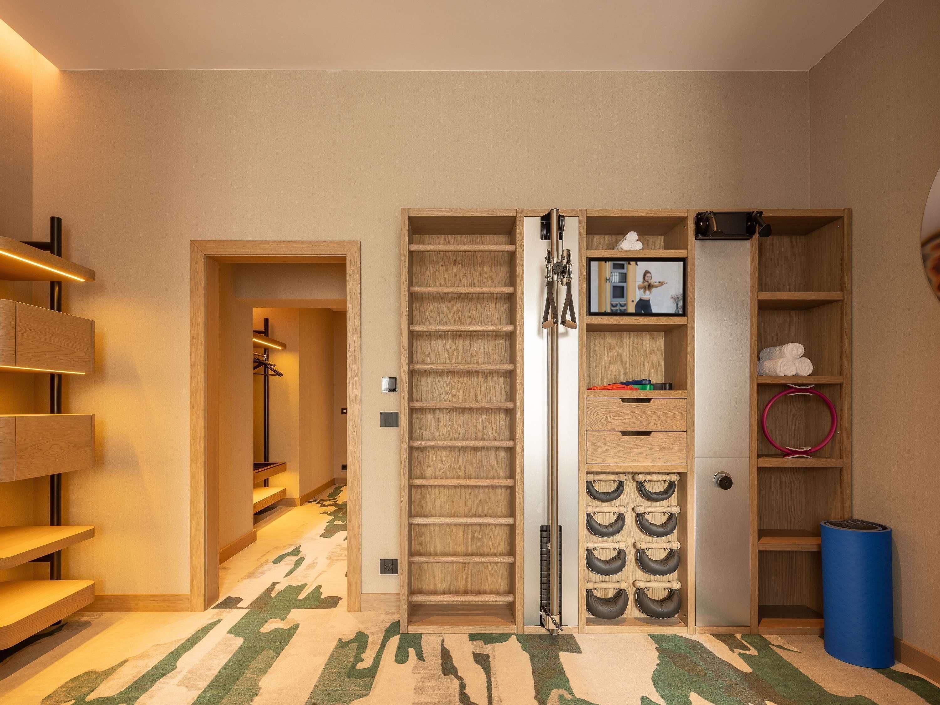 Un couloir avec une armoire en bois, un miroir et une étagère où sont posées des serviettes.