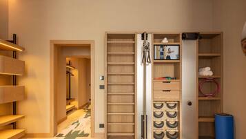 Un couloir avec une armoire en bois, un miroir et une étagère où sont posées des serviettes.
