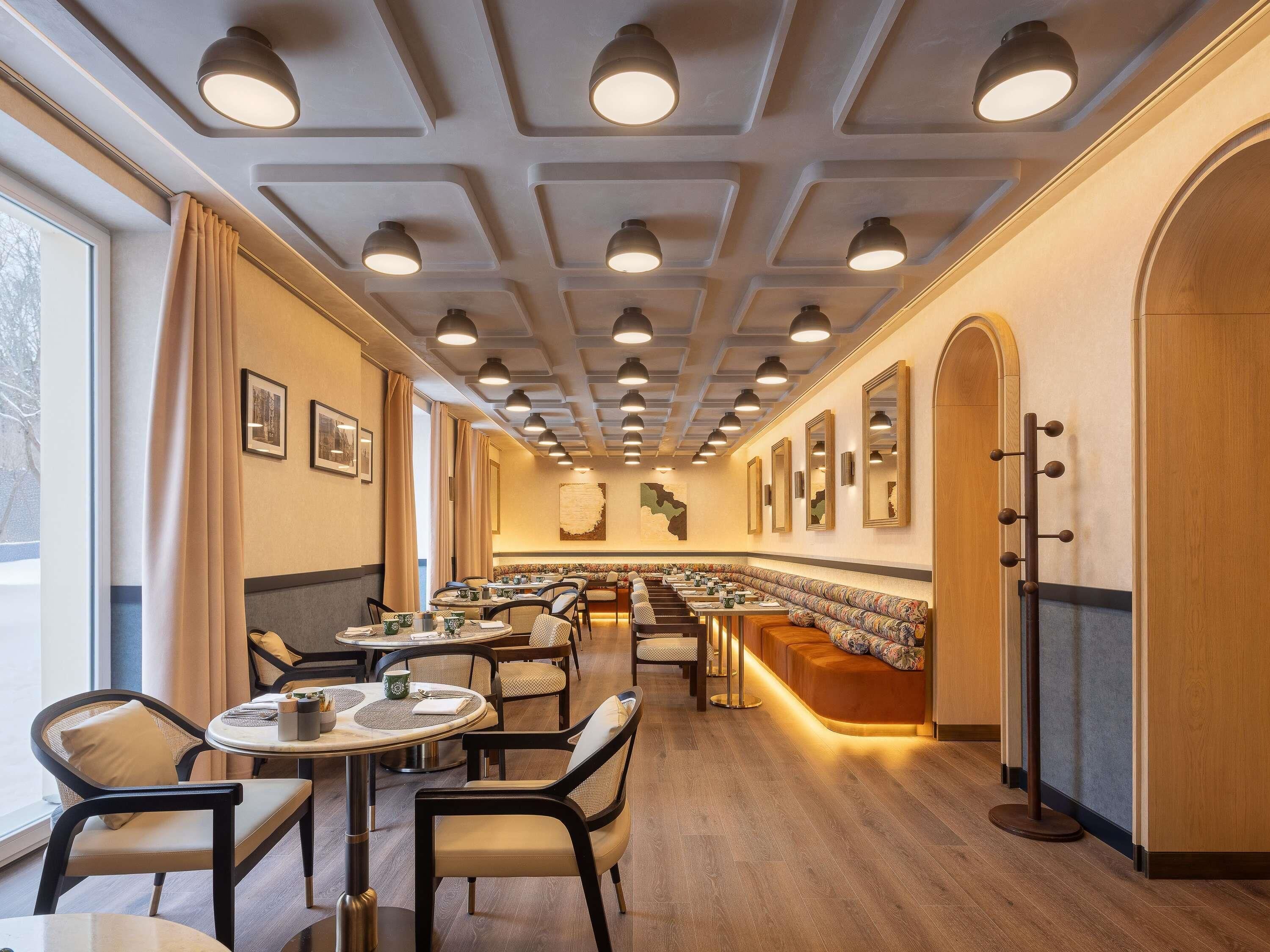 Ein Restaurant mit einer langen Theke, mehreren Tischen und Stühlen.