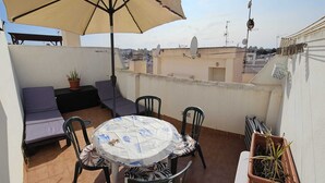 A rooftop terrace with a round table, chairs, a sofa, and an umbrella. - Fantastic 4-bedroom apartment, only 150m from the beach of Los Locos, Torrevieja (Torrevieja)
