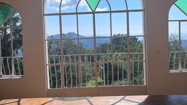 Una habitación con un amplio ventanal arqueado que da a un paisaje montañoso.