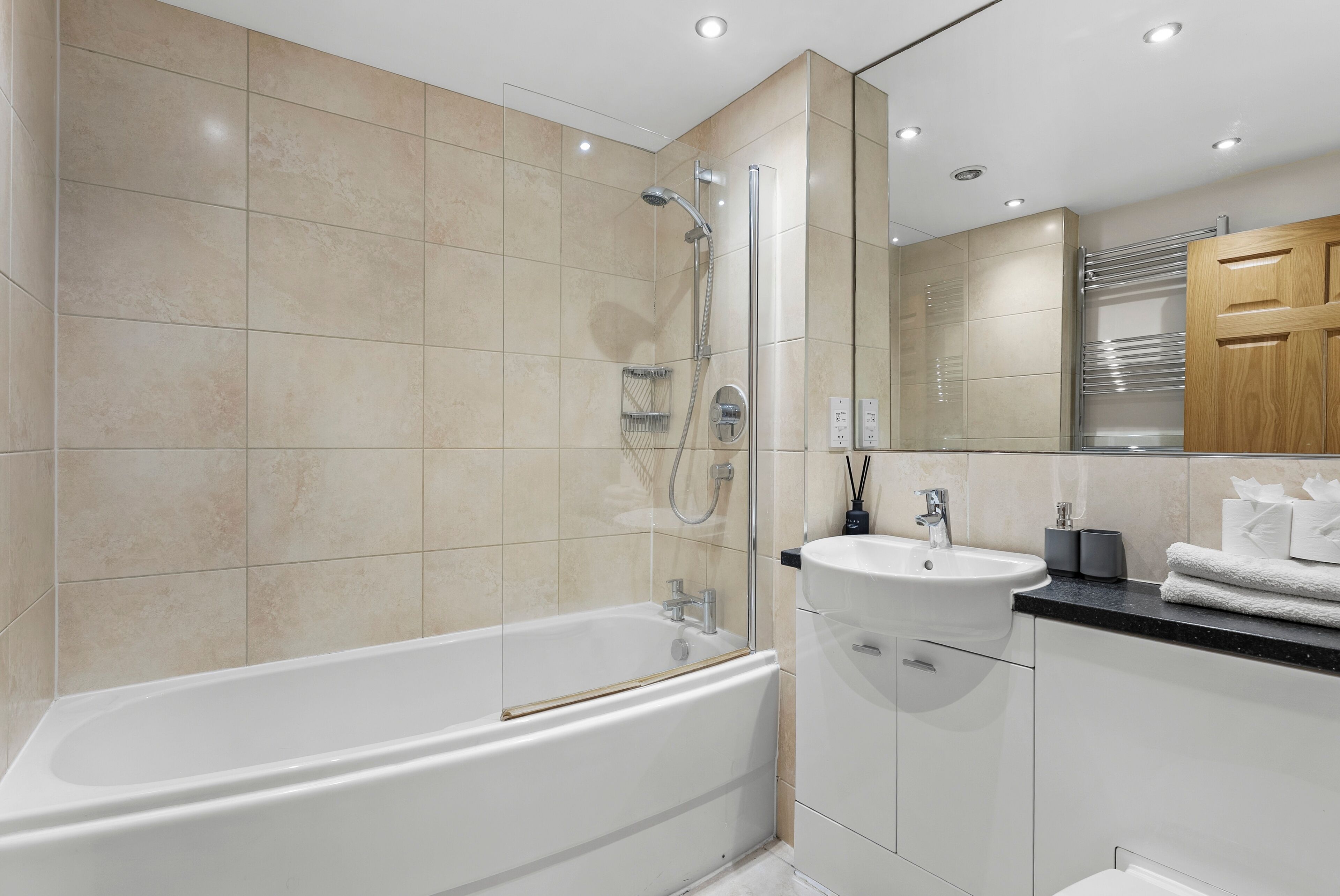 Ein modernes Badezimmer mit Badewanne, Dusche und Waschbecken.