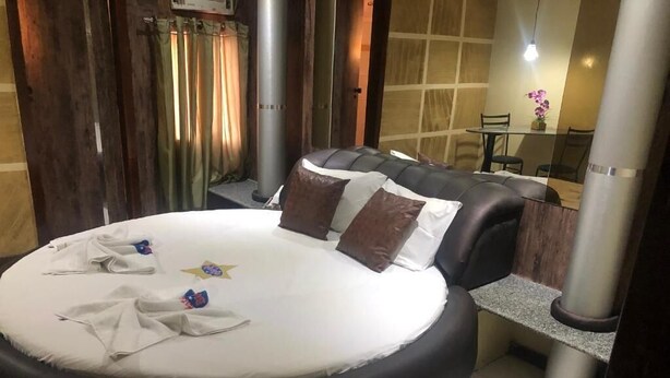 A round bed with a white mattress, two pillows, and a towel.