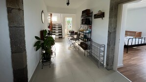 Un corridoio con una scala che conduce a un'altra stanza, una sala da pranzo con tavolo e sedie, e un letto nella stanza adiacente.