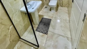 A bathroom with a sink, toilet, and shower area. - Great Pyramids Lodge (Giza)