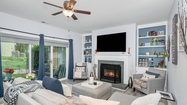 A modern living room with a fireplace, comfortable seating, and a large TV.