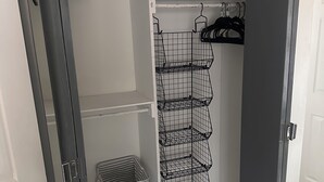 A walk-in closet with a grey door, a hanging rod, and a wire shelf unit. - Charming 3-bedroom house with AC in nice Hope Hull. (hope hull)