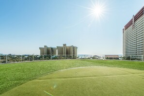 A golf course with a clear sky and buildings in the background. - Laketown Wharf 331 (Panama City Beach)