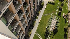 Un edificio de gran altura con múltiples balcones, un patio central con diseño geométrico y una escalera en espiral.