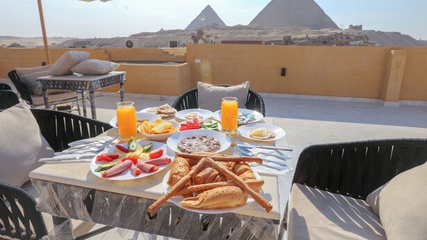 A table set for breakfast with a view of the pyramids. - Great Pyramid View Inn (Giza)