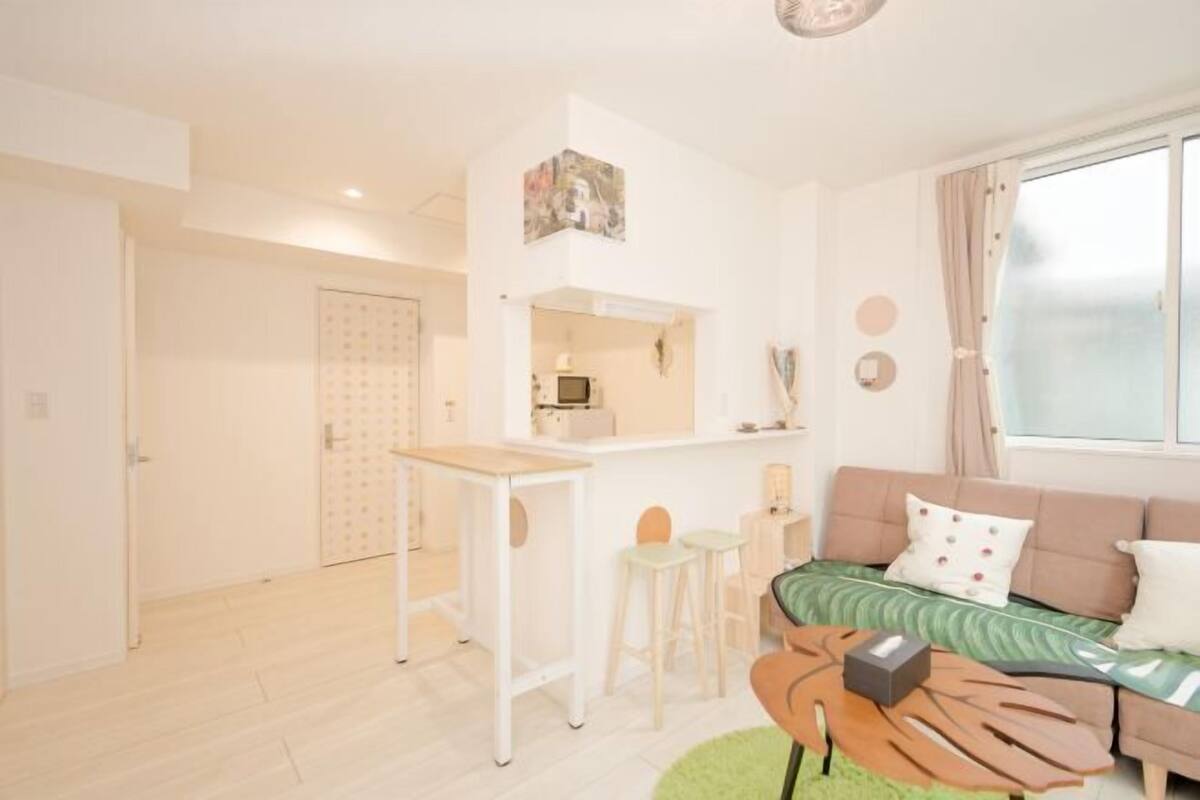 Una sala de estar moderna con un sofá, una mesa de centro y una pequeña cocina.