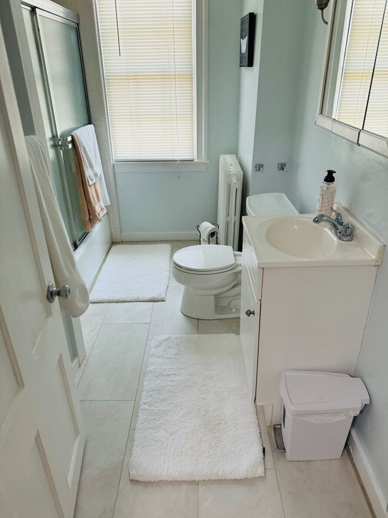 A small, clean bathroom with a toilet, sink, and shower.