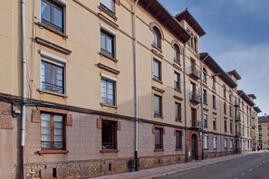 Un edificio de varios pisos con un estilo arquitectónico uniforme, que cuenta con varias ventanas y balcones.