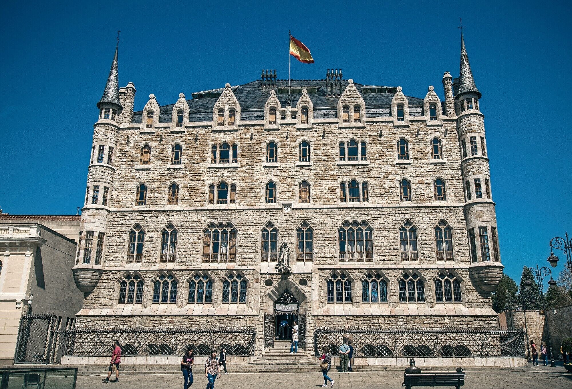 Un grand bâtiment en pierre, doté de nombreuses tours et de fenêtres en arc, qui semble être un monument historique ou un lieu d’importance particulière.